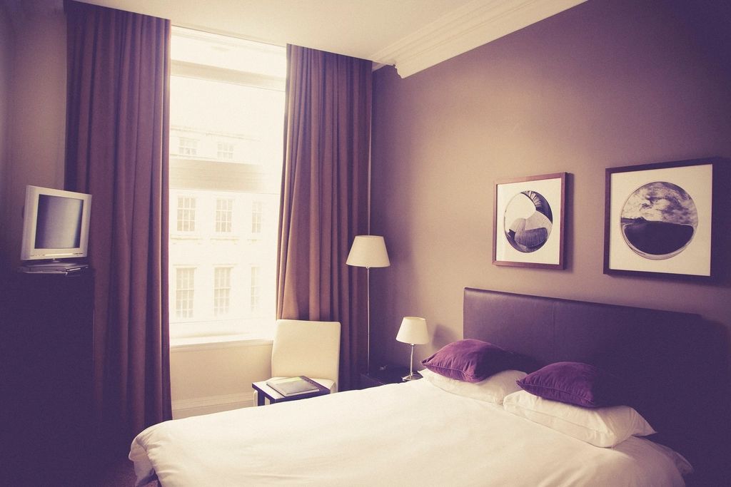 A guest room with a large bed and soft lighting